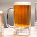 A Libbey glass mug filled with brown beer on a table.