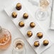 A chocolate covered round dessert with 24K edible gold crumbs on top.