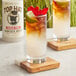 A glass of brown liquid with ice and a lime on a coaster with a Top Hat Provisions Sugar-Free Spicy Ginger Beer label.