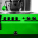 A green Primo coffee roaster with black buttons and a green screen.