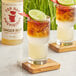 A glass of Top Hat Provisions Spicy Ginger Beer with lime on a coaster.