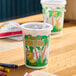 A 12 oz. kid's cup with a jungle print design, lid, and straw.