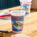 A 12 oz. kid's cup with a colorful imagination-themed print, plastic lid, and straw.