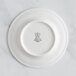 A white RAK Porcelain flat plate with an embossed crown on the rim.