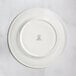 A RAK Porcelain ivory flat plate with an embossed crown on the rim.