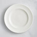 A close-up of a RAK Porcelain ivory saucer with a swirl pattern.