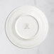 A RAK Porcelain ivory flat plate with an embossed crown logo on the rim.