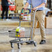 A man pushing a Regency supermarket shopping cart full of food.