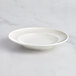 A RAK Porcelain ivory porcelain deep plate with an embossed rim.