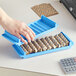 A hand holding a blue plastic Controltek USA coin tray with brown wrapped nickels.