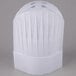 A close up of a white Royal Paper disposable chef hat with pleats.