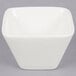A white square American Metalcraft porcelain sauce cup on a gray surface.