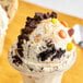 A scoop of Cookie Dough Bliss peanut butter and cookies cookie dough on a bowl of ice cream.
