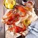 Steamed Chesapeake blue crabs on paper with lemons and beer.