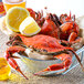 A bowl of Chesapeake blue crabs with lemon slices.