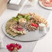 A Choice aluminum pizza pan filled with a variety of food on a table at a catering event.