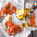 Steamed Chesapeake blue crabs on newspaper with lemons and beer.