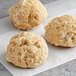 A group of round brown Chesapeake Crab Connection Blue Crab Cakes on a white surface.