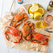 Steamed Chesapeake Blue Crabs on a table with lemons and beer.