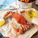 A Chesapeake blue crab on a paper with a lemon slice.