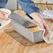 A person using a Chicago Metallic aluminized steel loaf pan to bake bread.