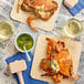 A cooked female blue crab on a wooden board.