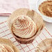 A cinnamon swirl cupcake with brown and white swirly sprinkles.