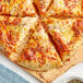 Slices of cheese pizza with Regal Pizza Seasoning on a wooden board.