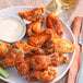 A plate of Regal Brown Sugar Wing Rub chicken wings with a side of dipping sauce.