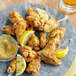 A plate of chicken wings with lemon slices and Regal Lemon Pepper Wing Rub.