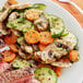 A plate of food with vegetables and meat seasoned with Regal Vegetable Seasoning on a table.