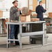 A man standing on a Lavex steel workbench top with boxes.