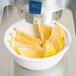 Lemon wedges in a bowl being squeezed into a juicer.