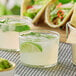 Two Bodega by Bormioli Rocco mini tumblers filled with margaritas on a table with tacos.