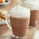 A glass mug of Land O Lakes Cocoa Classics Oatmeal Cookie hot chocolate with a cookie on the side.