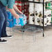 A man and woman placing plastic bottles of water on a Regency steel wire rack.