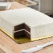 A cake with a layer of chocolate and vanilla on a gold laminated cake board.