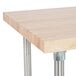 An Advance Tabco wood top work table with a stainless steel base and undershelf.