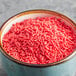 A bowl of Bake-Stable Red Sprinkles.