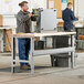 A man standing at a Lavex Maple workbench top writing on a clipboard.