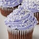 A close-up of a cupcake with purple frosting and Bake-Stable White Sprinkles.