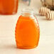 A Classic Queenline PET honey jar with a lid on a table.