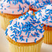 A close up of a cupcake with blue sprinkles.