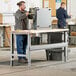 A man working on a machine at a Lavex heavy-duty workbench.