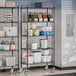 A Steelton black wire shelving kit with casters in a kitchen with food on the shelves.