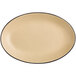 An Acopa Harvest Tan matte stoneware platter with a black rim on an oval shape.