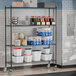 A Steelton black metal wire shelving unit with food items on it.
