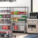 A Steelton wire shelving kit with black shelves and casters holding beverages.