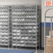 A Regency metal wire shelving unit with clear plastic bins on it.