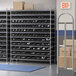 A storage room with Regency wire shelving filled with black bins.